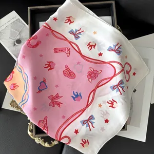 Detail of pink floral silk scarf with vintage western prints on a black tray