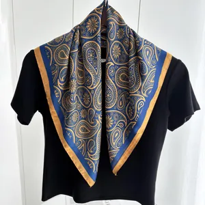 Detail eines luxuriösen Seidenschals mit Marine-Paisley und goldenen Vintage-Mustern