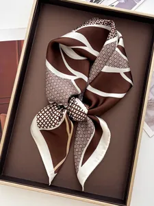 Detailed view of folded silk scarf with brown geometric patterns and floral accents