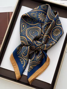 Detail eines luxuriösen marineblauen Seidentuchs mit goldenem Paisley-Muster und Glanz
