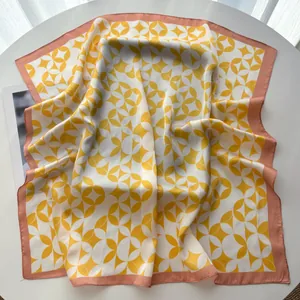 Detail of yellow and white geometric pattern silk scarf with pink stitched edges