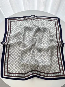 Detailed close-up of a geometric print square silk scarf with navy borders and soft luster