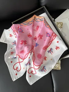 Detail of silk floral scarf featuring pink patterns on a luxury magazine background