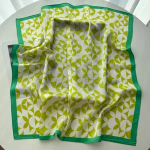 Close-up of vintage paisley silk square scarf with green leaf patterns and satin finish