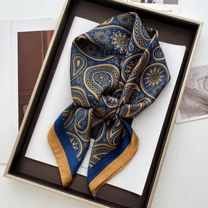 Detail eines luxuriösen marineblauen Seidentuchs mit goldenem Paisleymuster in Box