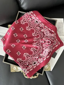 Detail of red paisley silk satin scarf on a vintage tray with elegant folds and gloss