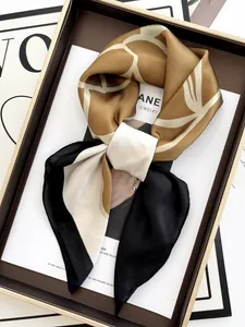 Dettaglio di un foulard in seta a camelia annodato con eleganza in una scatola regalo dorata