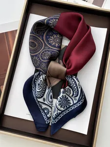 Close-up of silk scarf featuring paisley patterns and elegant wine red color blocking