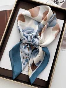 Gros plan d'un foulard en soie à fleurs abstraites dans un coffret cadeau élégant