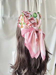 Detail of pink floral satin scarf tied as a bohemian headpiece on long hair