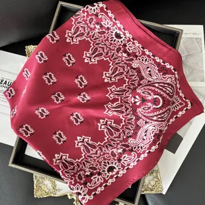 Elegant burgundy paisley silk scarf on a vintage gold tray with stylish magazine background