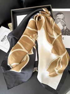 Dettaglio di foulard in seta a camelia piegato su vassoio in legno con rivista di moda