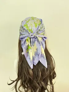 Detail of 100% polyester satin scarf with floral pattern shown as a headscarf wrap