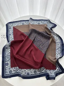 Detailed view of elegant paisley patterns on smooth satin scarf with geometric borders