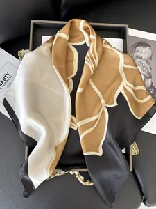 Dettaglio del foulard in seta a fiori di camelia con stampa dorata e trama morbida