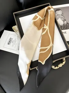 Dettaglio di sciarpa in seta a fiori di camelia con patchwork caramello e nero liscio