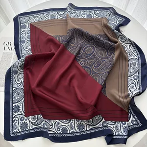 Detailed shot of a silk scarf with burgundy paisley pattern and geometric blocks on a table