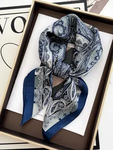 Dettaglio di un foulard in seta blu con motivo paisley in una scatola regalo di lusso