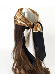 Detail of camellia silk scarf tied as a headband with abstract caramel patterns