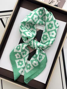 Detailed macro of green checkered floral silk scarf tied as a bow in a gift box