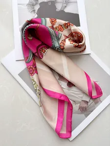 Close-up of pink and cream silk-like satin scarf with retro chain patterns on magazines