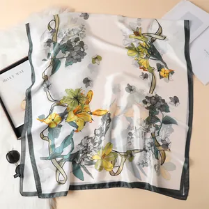 Elegant floral satin scarf with yellow lily and green leaf patterns on cream silk