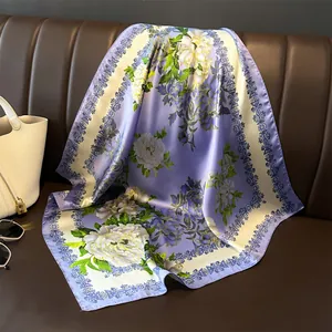 Elegant 70cm satin silk square scarf with purple floral print draped on a leather sofa