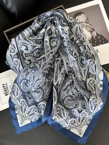 Dettaglio del foulard in raso blu e bianco con motivo paisley e trama di seta