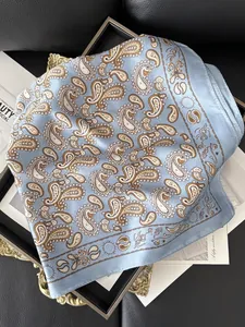 Détail d'un foulard en soie bleu clair avec motif paisley sur un magazine de mode vintage