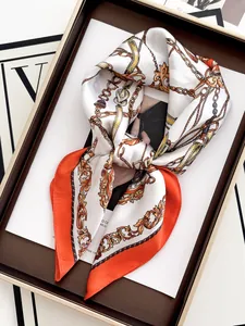 Detail of luxury silk square scarf with baroque chain print in orange and pearl white