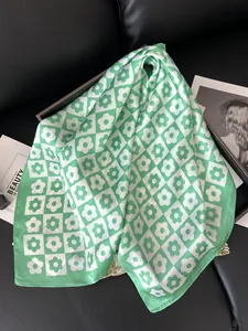 Detail of floral checkerboard satin scarf in light green and white with elegant sheen