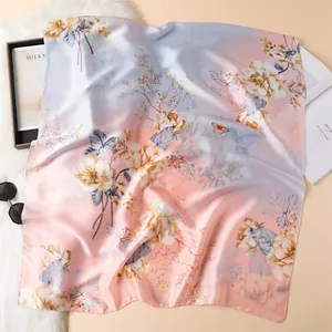 Detail van elegante zijden sjaal met bloemenprint en vlinderpatronen op luxe stof