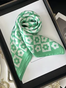 Detail of green floral checkered silk scarf with satin finish and rolled edge stitching