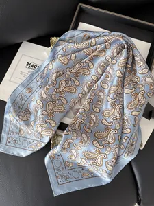 Vue détaillée du motif cachemire sur foulard en soie bleu clair au fini satiné