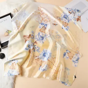 Detail van elegante zijden sjaal met blauwe bloemen op champagne basis en pluche achterkant