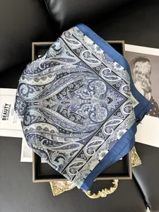 Vista macro dettagliata del foulard di seta blu e bianco con motivo paisley su un vassoio