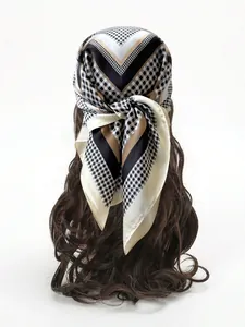 Detail view of square scarf with geometric pattern worn on head with brown wavy hair