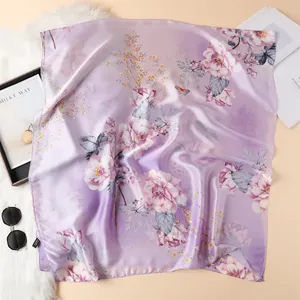 Detail van een zijden sjaal met lila verloop en geprinte patronen van pioenrozen