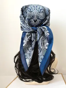 Close-up of blue paisley silk scarf styled as a headband on a brunette mannequin head