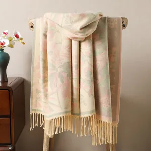 Détail d'un châle jacquard floral avec franges à glands sur un support en bois