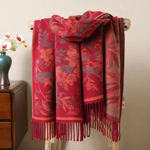 Détail d'écharpe en jacquard rouge à motif floral avec de longues franges souples