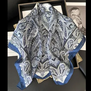 Foulard di seta classico blu scuro e bianco con motivo paisley su vassoio dorato