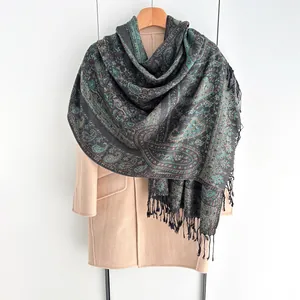Détail de châle vintage à motif cachemire et franges sur manteau beige élégant