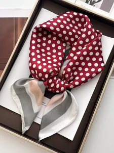 Close-up of elegant polka dot silk scarf with geometric patterns in a premium gift box
