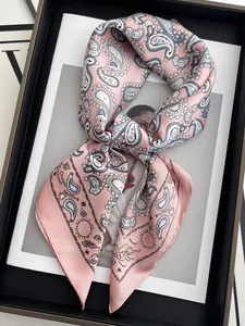 Détail d'un foulard en satin rose à motif paisley et motifs célestes sur magazine