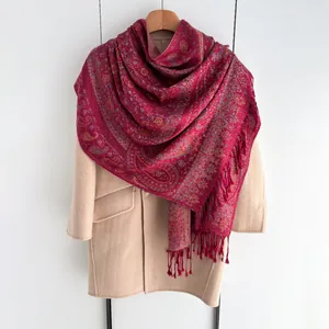 Détail d'un châle jacquard rouge foncé à motifs cachemire et longues franges