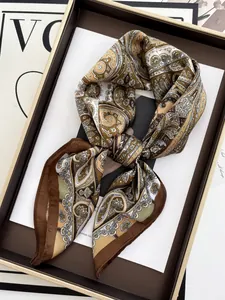 Detail of silk-satin paisley scarf in gold and olive green within a premium gift box