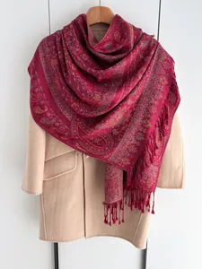 Détail d'un châle vintage à motifs paisley rouge avec jacquard et bordure à franges