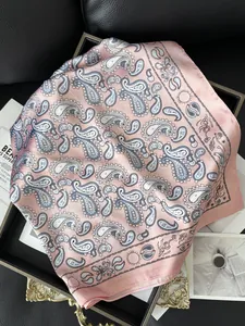 Vue détaillée d'un foulard en soie rose avec motifs Paisley et détails de soleil et lune