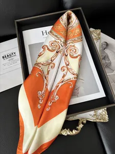 Detailed view of baroque patterned orange silk scarf on a vintage tray